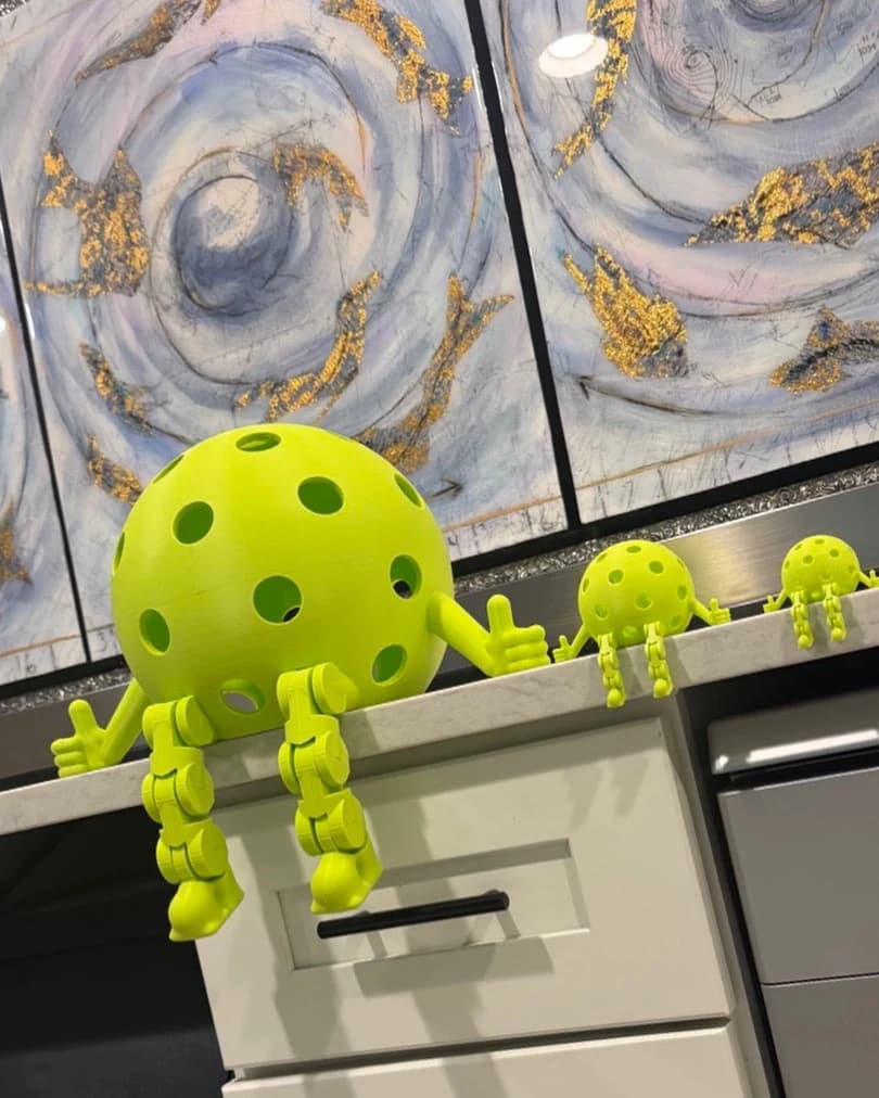 A Huge, a Regular and a Small Pickleball Dinky sitting along a kitchen counter